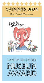 A portrait banner with a yellow section at the top saying Winner 2024 Best Small Museum. beneath this is an illustration of a pink mammoth with people of all ages gathered round. At the bottom it says Family Friendly Museum Award.